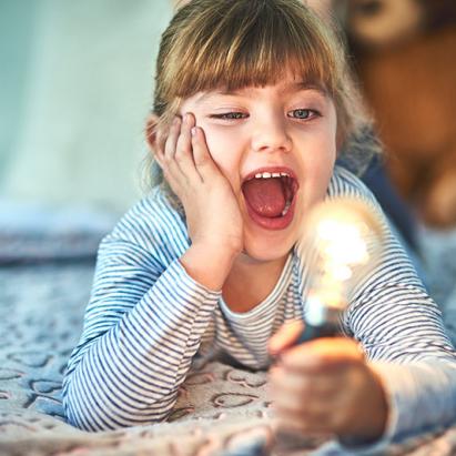 Enfant éclairée d'une ampoule